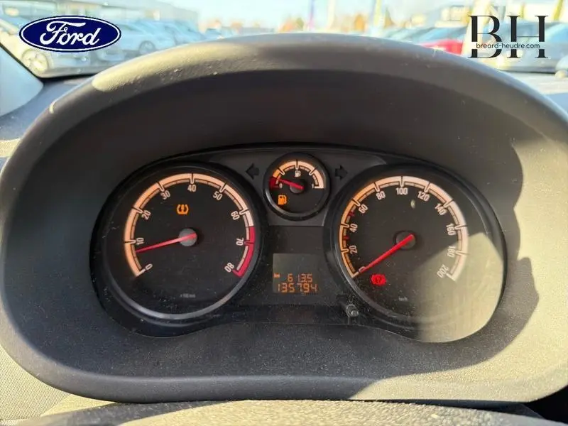 Gros plan sur le tableau de bord d'une Opel Corsa gris minéral, affichant le compteur de vitesse et le compte-tours.