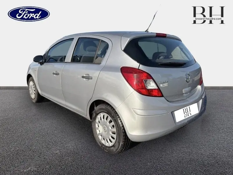 Opel Corsa gris minéral vue 3/4 arrière droit, compacte cinq portes avec feux arrière rouges et becquet discret.