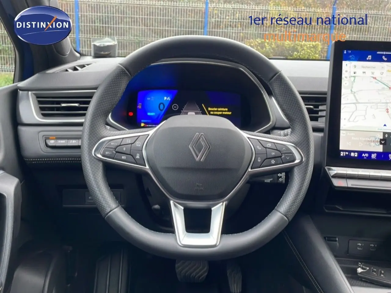 Vue frontale du volant noir perforé de la Renault Symbioz E-Tech Full Hybrid 145ch Iconic avec tableau de bord digital et écran tactile.