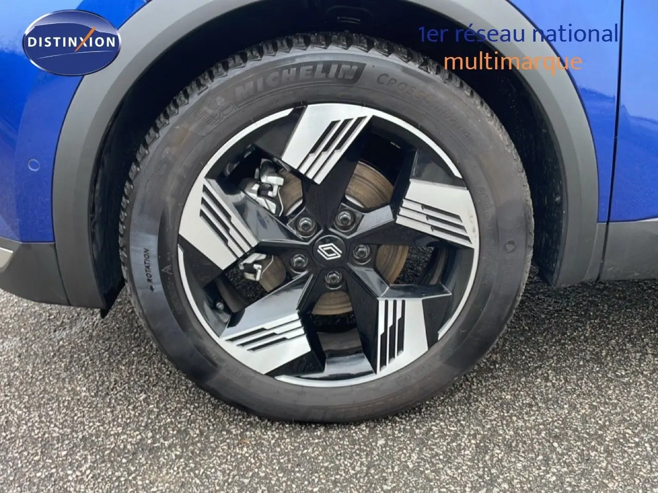 Gros plan sur la roue avant gauche bleu iron metal de la Renault Symbioz E-Tech Full Hybrid 145ch Iconic avec jante noire et argent.