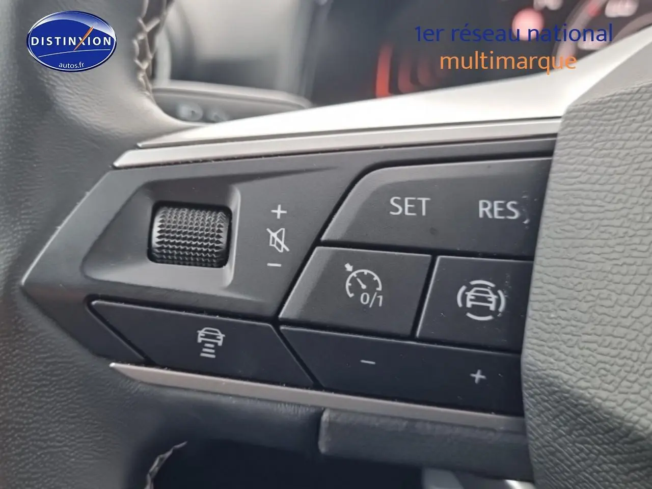 Gros plan sur les commandes du volant cuir noir de la SEAT Arona 2025, avec boutons de régulateur de vitesse et aides à la conduite.