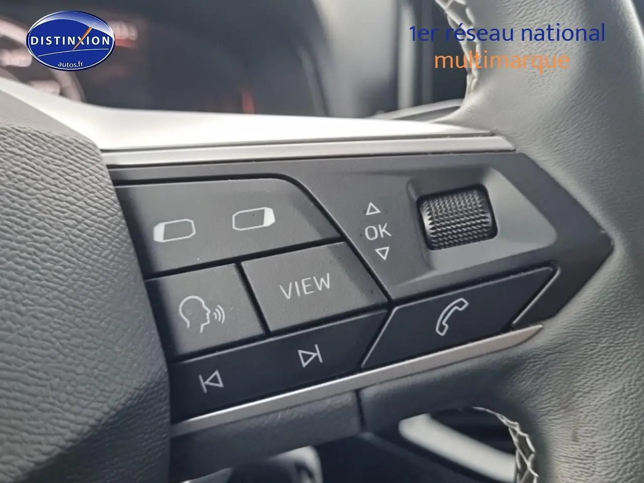 Gros plan sur les commandes multifonctions du volant cuir noir du SEAT Arona gris magnétique 2025.