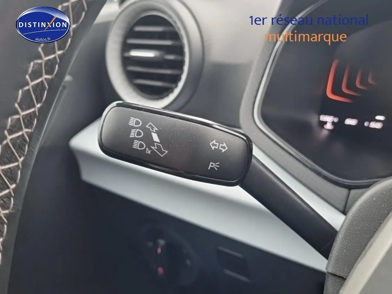 Gros plan sur la commande de clignotants et feux au volant d'un SEAT Arona gris magnétique 2025.