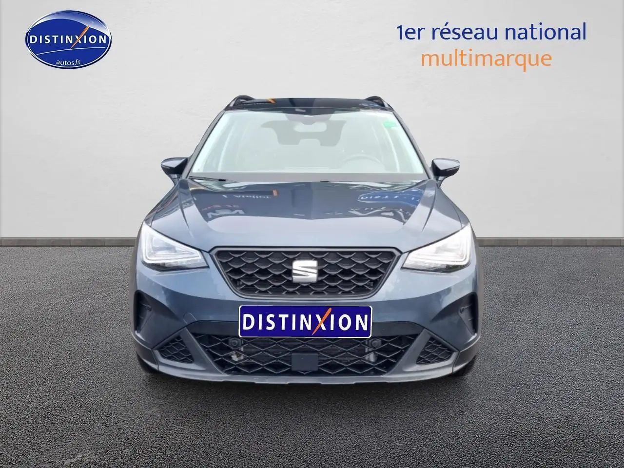 Vue avant d'une SEAT Arona 2025 gris magnétique avec calandre noire et projecteurs full LED allumés.