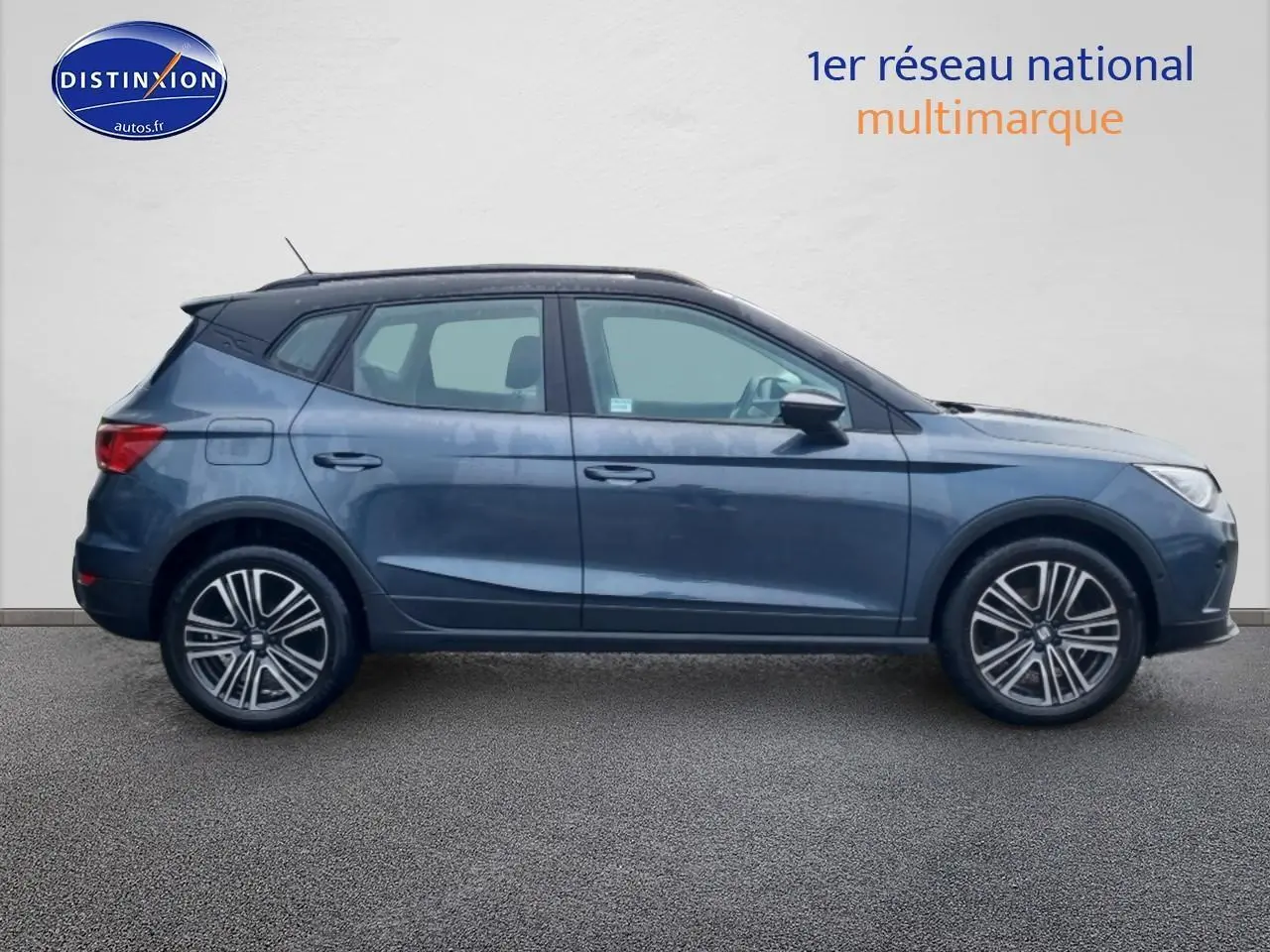 Vue latérale droite d'un SEAT Arona gris magnétique 2025 avec jantes 17 pouces et barres de toit noires.