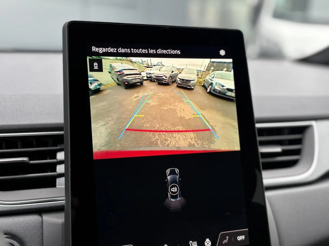 Écran central du Renault Captur 2025 affichant la caméra de recul avec lignes de guidage, intérieur gris.