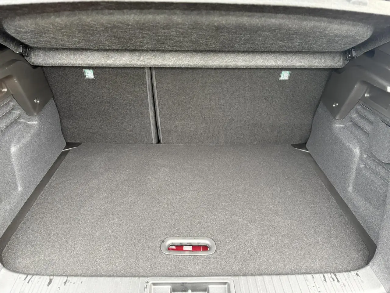 Coffre spacieux et propre du Renault Captur 2025, vue intérieure arrière avec plancher de coffre mobile fermé.