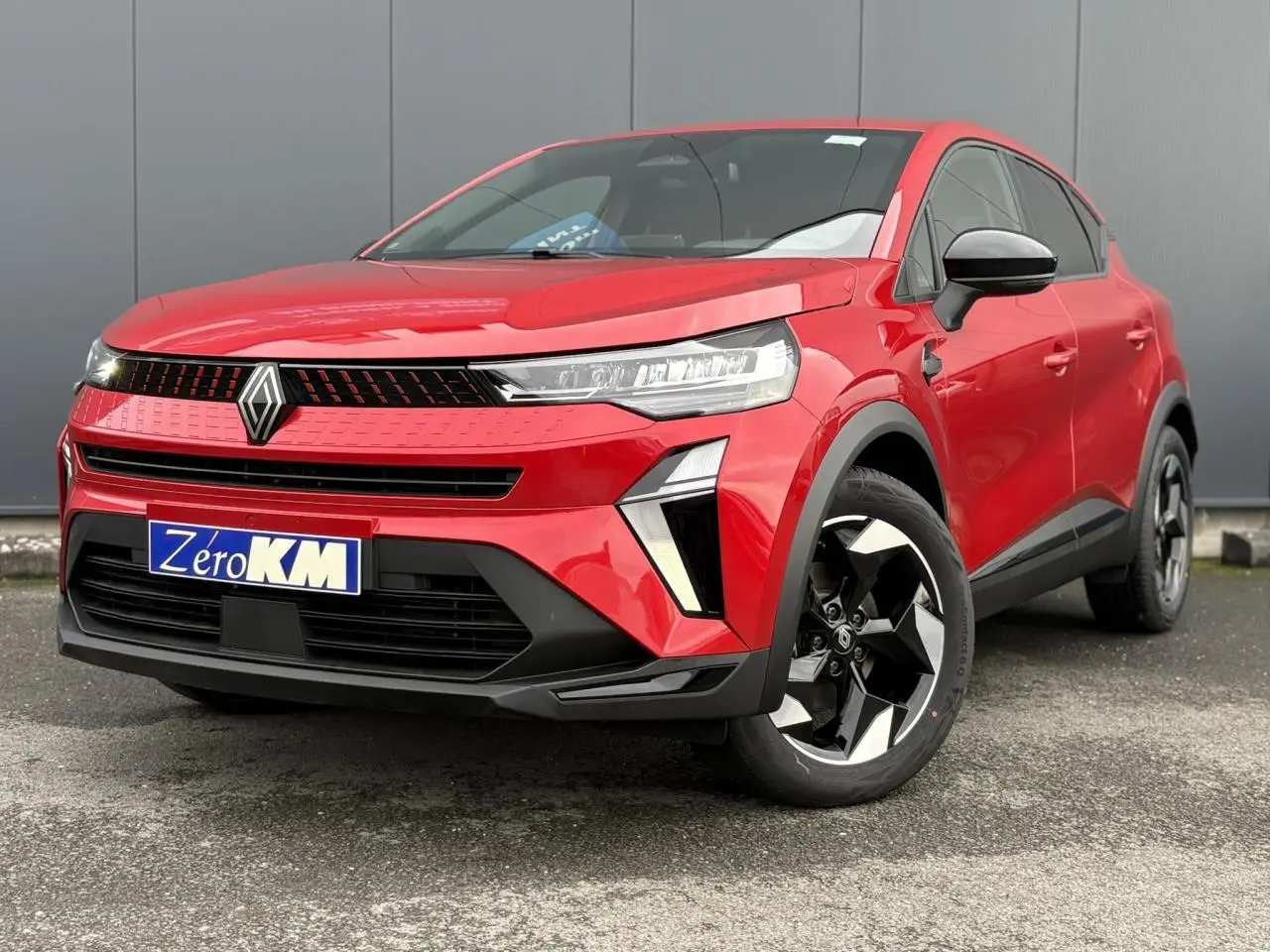 Renault Captur 2025 rouge flamme en 3/4 avant droit avec jantes aluminium noires et calandre moderne.