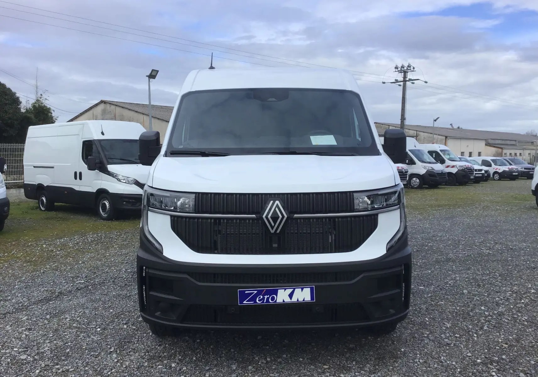 Vue de face d’un Renault Master blanc 2025 avec calandre noire et plaque d’immatriculation « Zéro KM » visible.