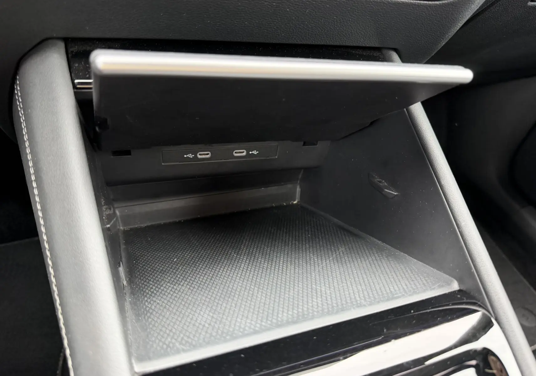 Rangement central ouvert avec deux ports USB-C visibles dans l'habitacle noir du Volkswagen Tiguan 2025.