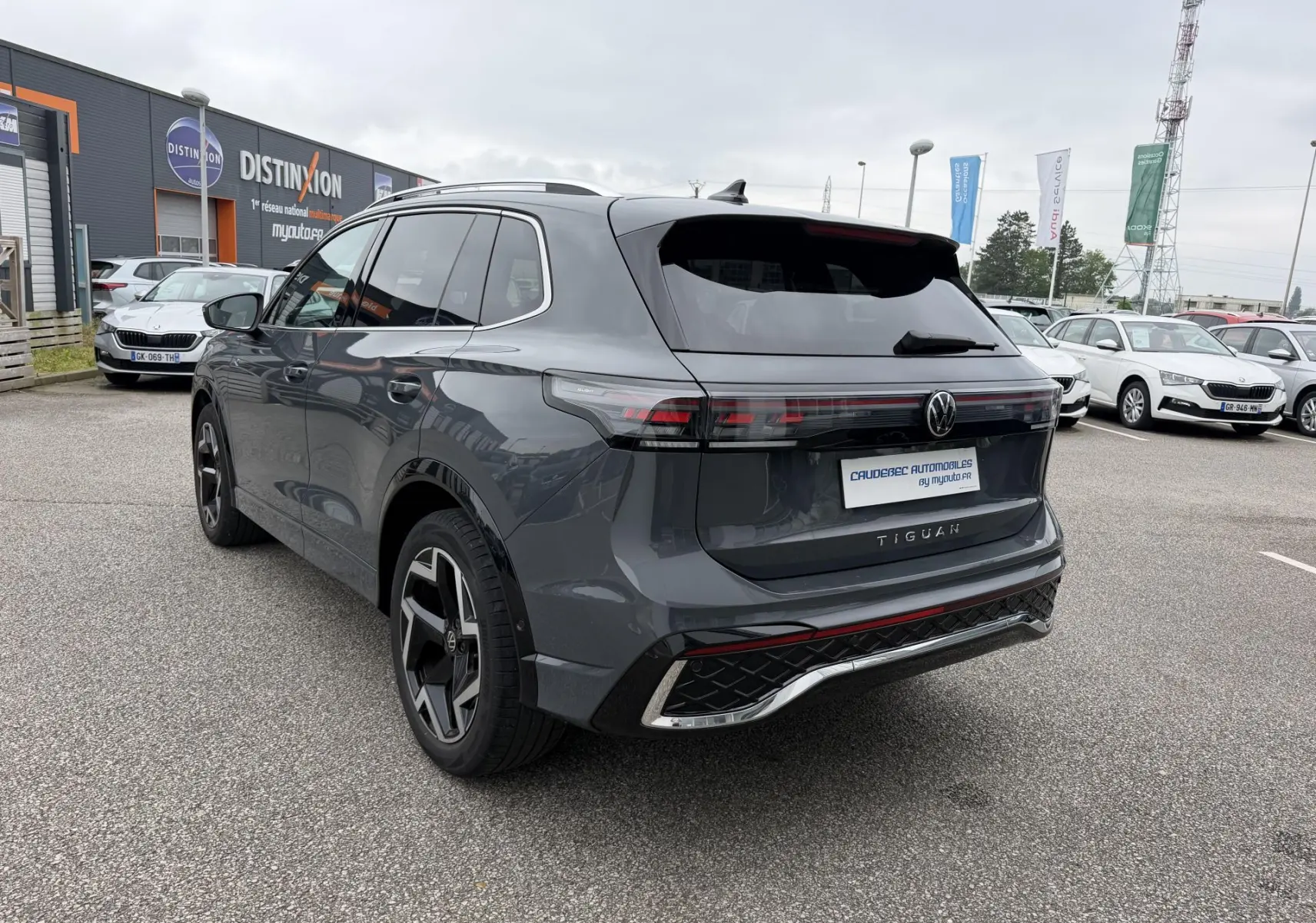 Vue 3/4 arrière droite d'un Volkswagen Tiguan gris métallisé avec jantes alliage 19 pouces et pack R-Line extérieur.