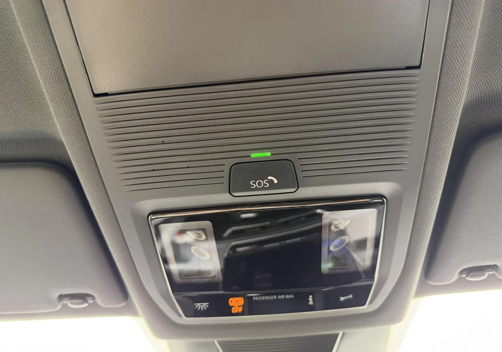Vue en contre-plongée du plafonnier gris avec bouton SOS et voyants d'airbag passager du Volkswagen Tiguan 2025.