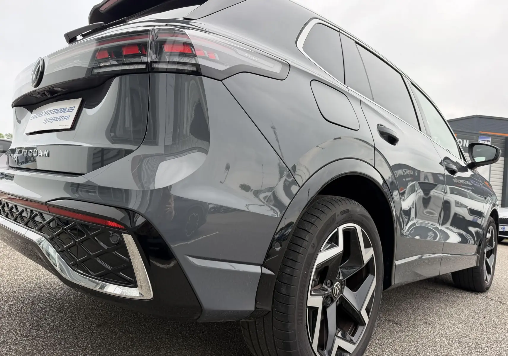 Vue 3/4 arrière droite du Volkswagen Tiguan gris métallisé avec jantes alliage 19 pouces et feux LED distinctifs.