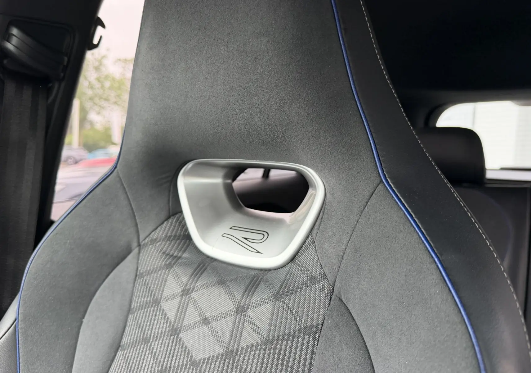 Gros plan sur le siège avant gris avec surpiqûres bleues et logo R du Volkswagen Tiguan 2025.
