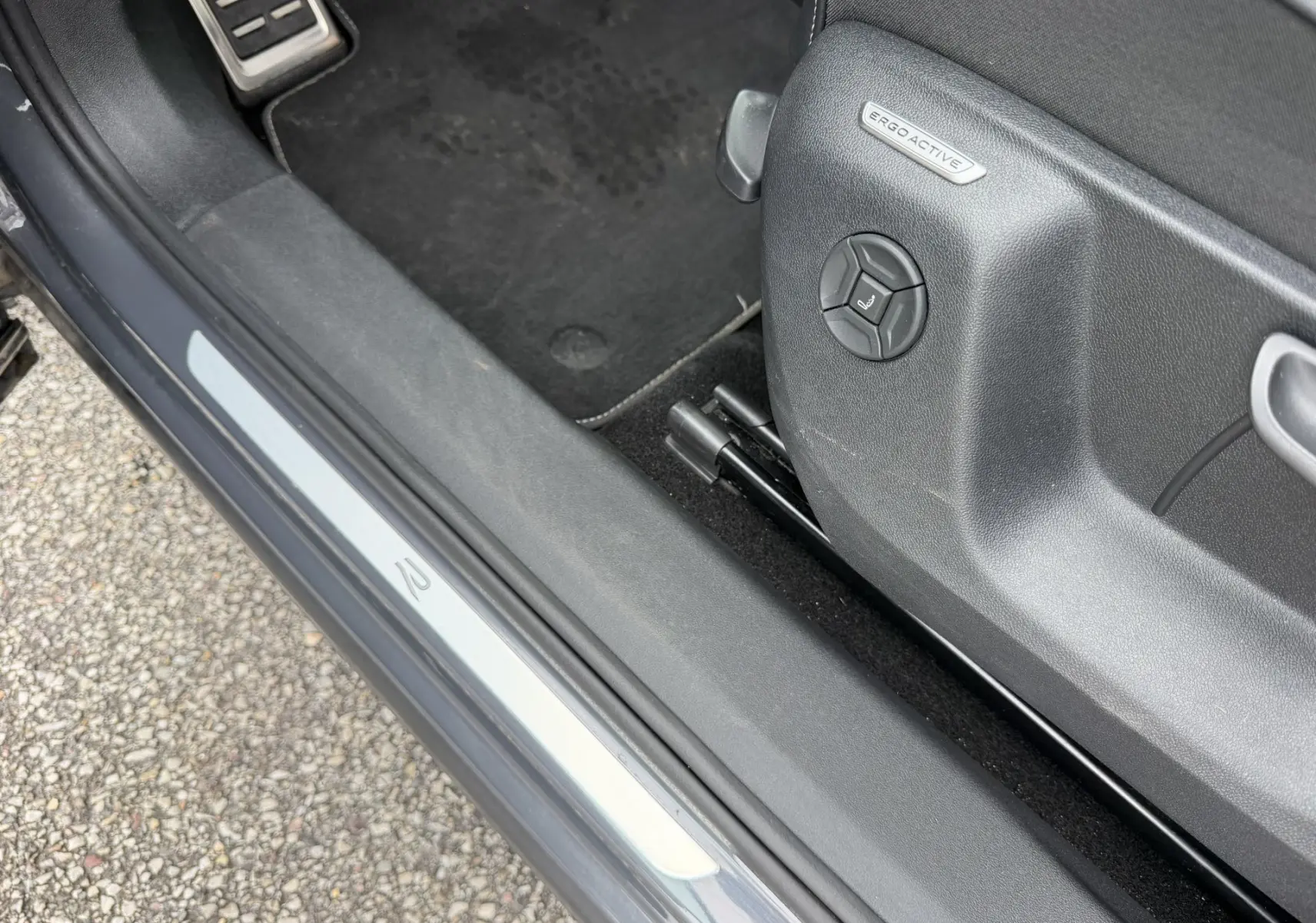 Vue rapprochée côté gauche du siège conducteur gris avec réglage ErgoActive et seuil de porte R du Volkswagen Tiguan 2025.