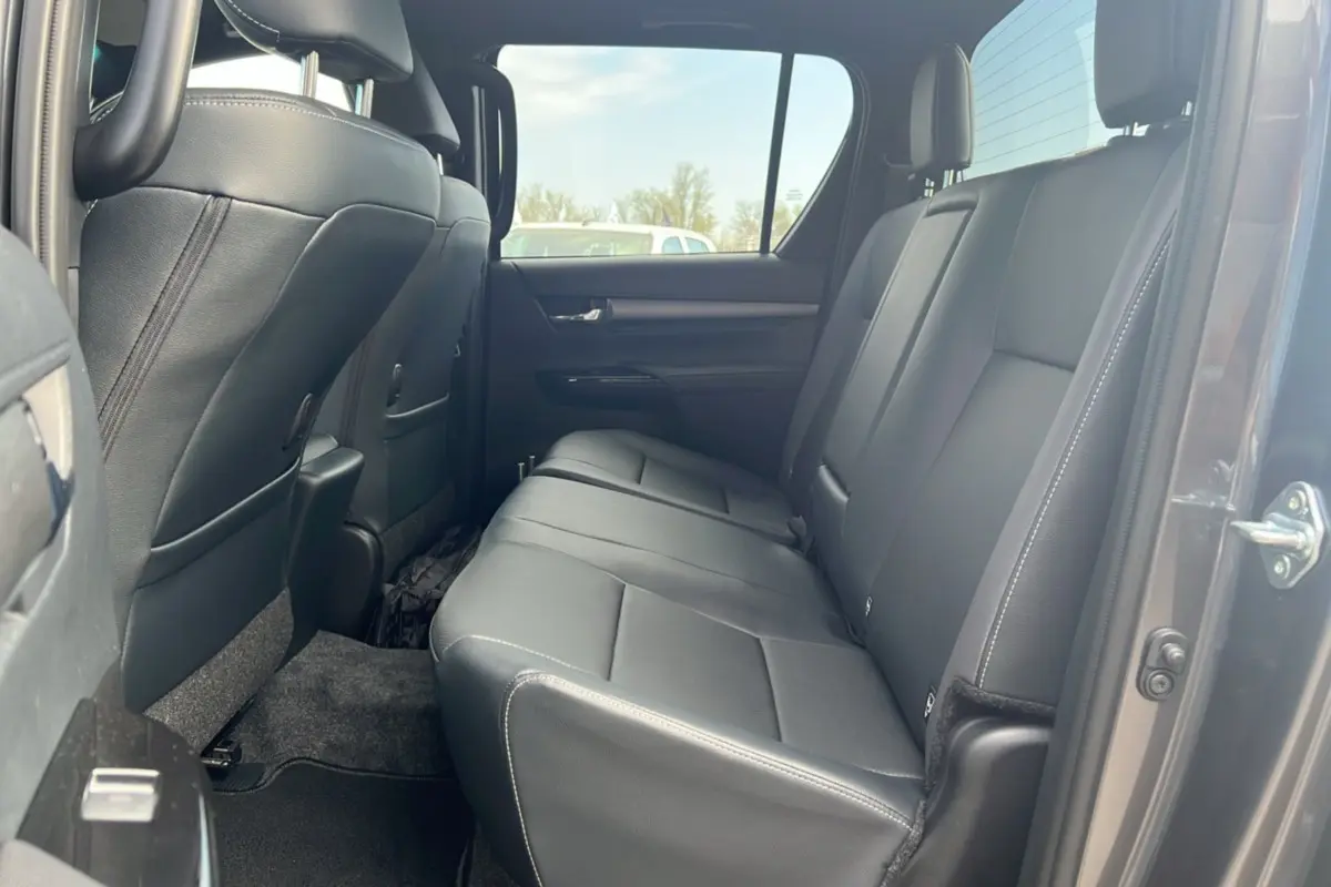 Vue intérieure côté droit sur la banquette arrière en cuir noir du Toyota Hilux 4x4 gris atlas 2025 Invincible.