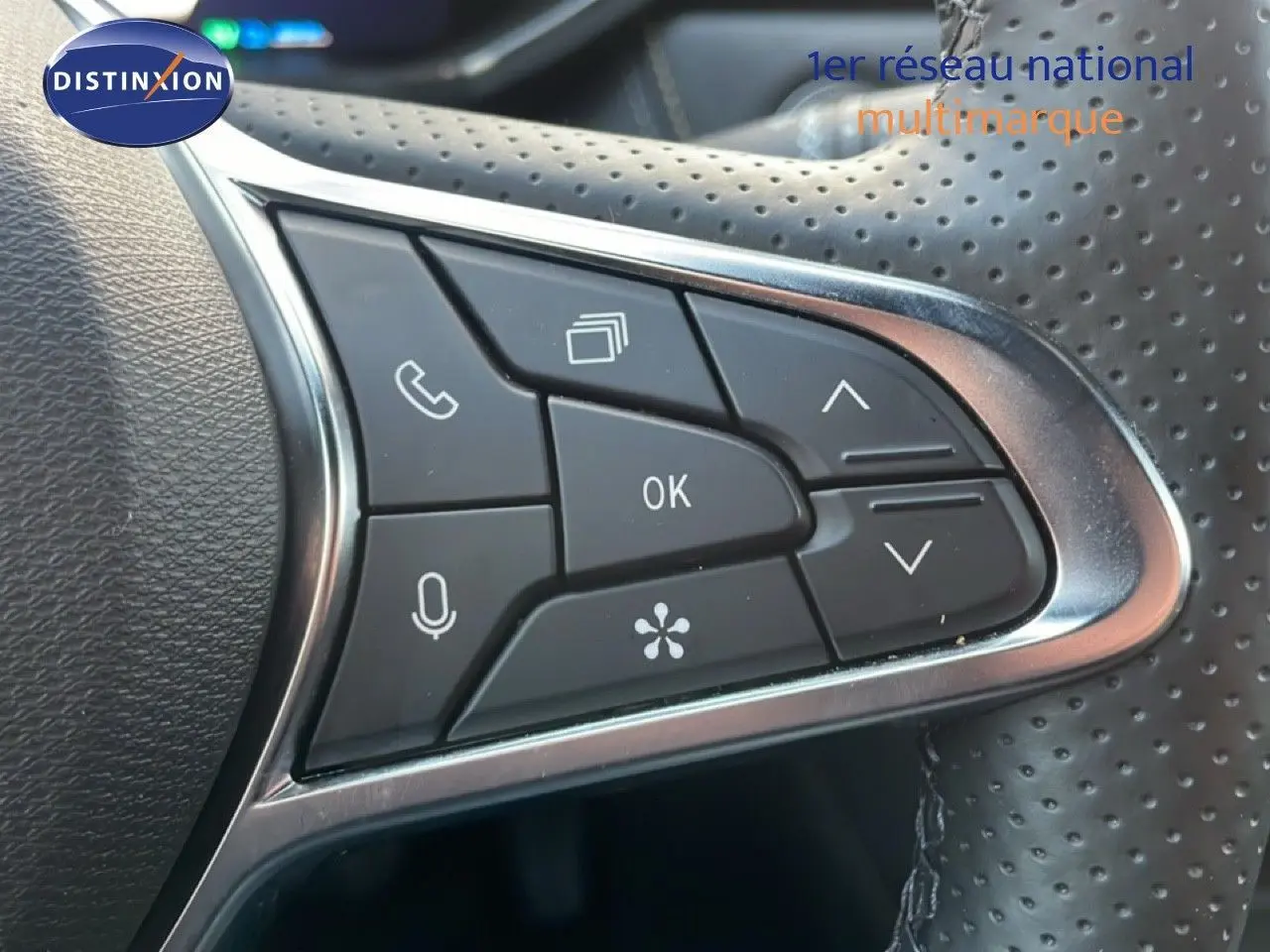 Gros plan sur les commandes multifonctions du volant perforé d’une Renault Symbioz gris cassiopée métal, version hybride 2025.