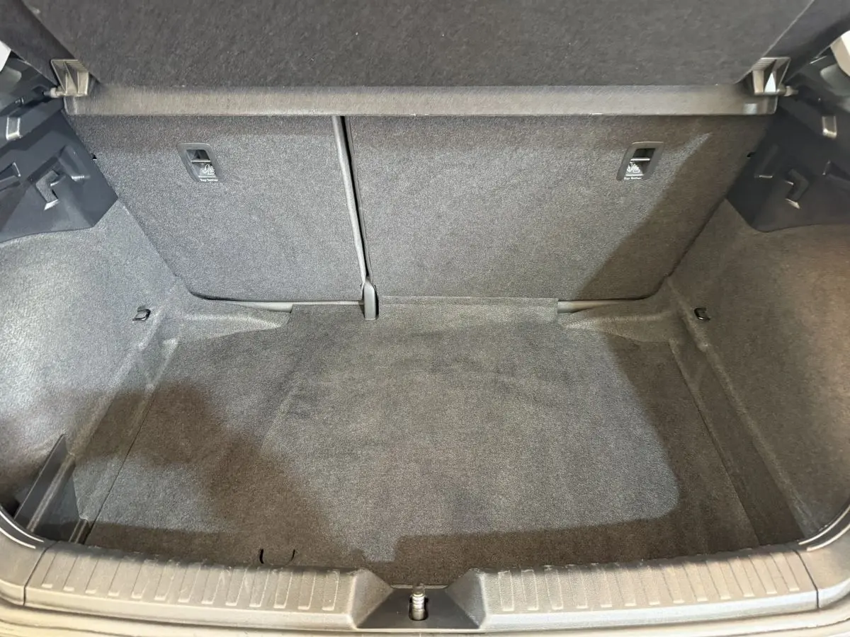 Vue intérieure du coffre spacieux et propre de l'Audi A1 noir, avec banquette arrière rabattable visible en arrière-plan.