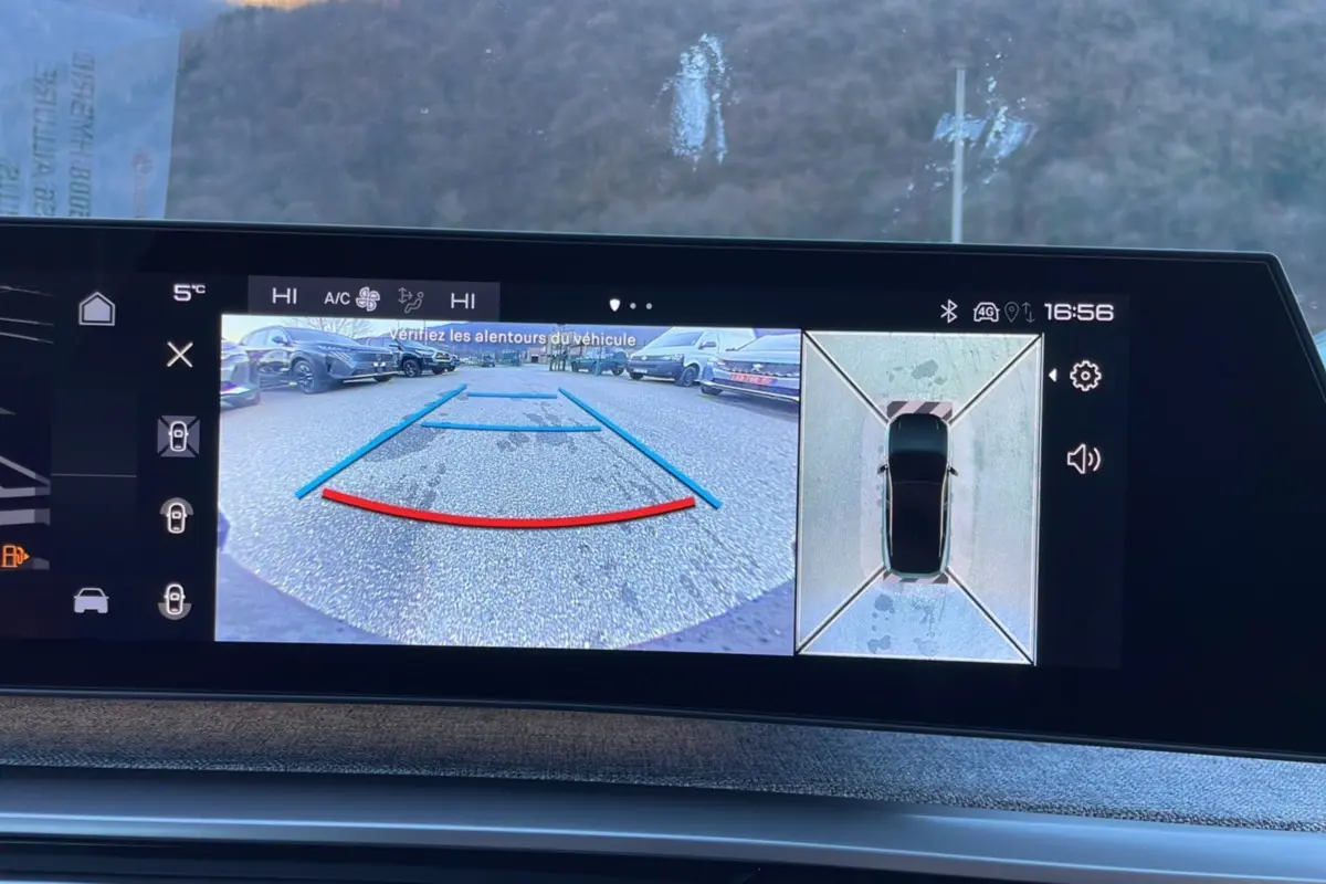 Écran de caméra 360° et recul affichant l'environnement autour du Peugeot 5008 gris titane en stationnement.