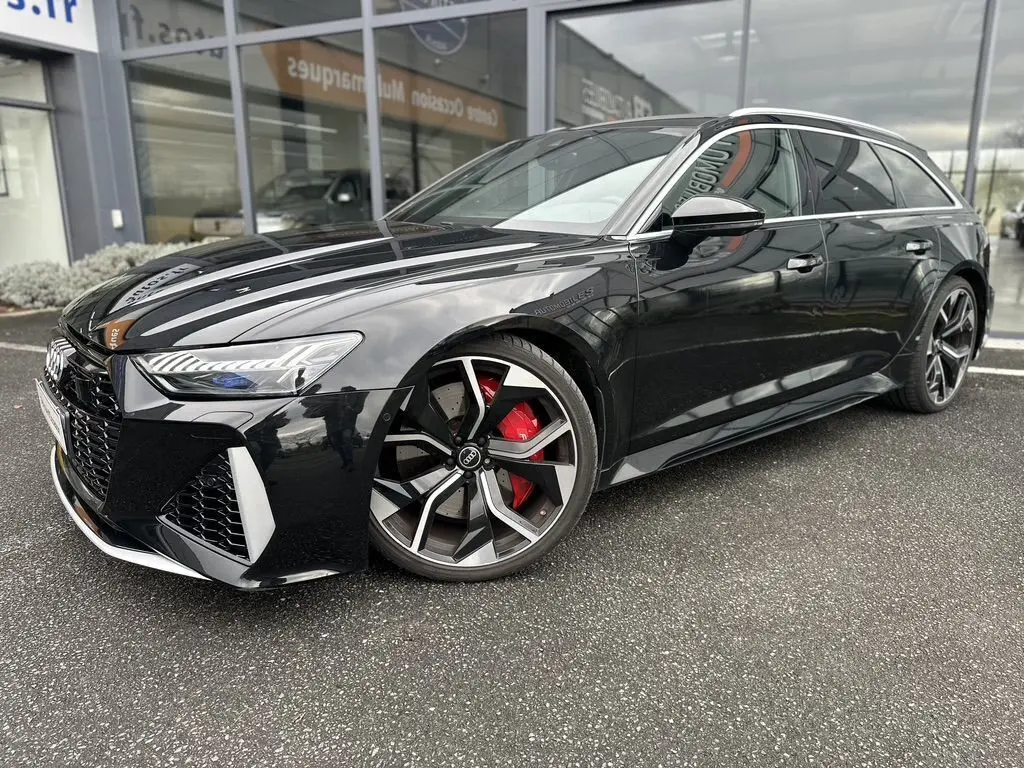 Audi RS6 Avant noire vue de 3/4 avant droit, avec jantes sport et étriers de frein rouges visibles.