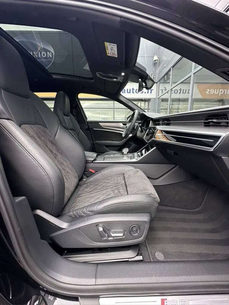 Vue intérieure côté conducteur de l'Audi RS6 Avant 2021 noire, avec sièges sport en cuir et alcantara, toit ouvrant panoramique.