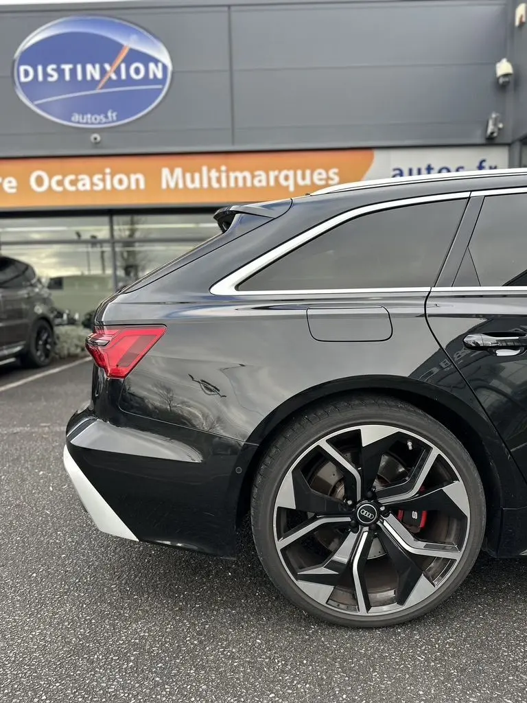 Vue 3/4 arrière côté gauche d'une Audi RS6 Avant noire avec jante alliage sport et vitres teintées.