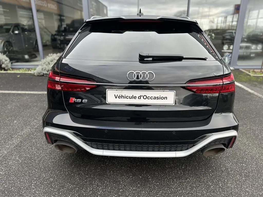 Vue arrière d'une Audi RS6 Avant noire de 2021 avec double sortie d'échappement et logo RS6 visible.
