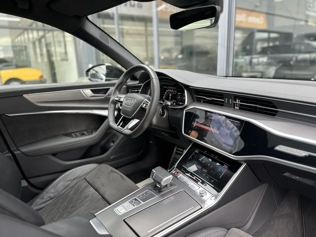 Intérieur noir de l'Audi RS6 Avant 2021 vu côté conducteur, avec tableau de bord digital et console tactile moderne.