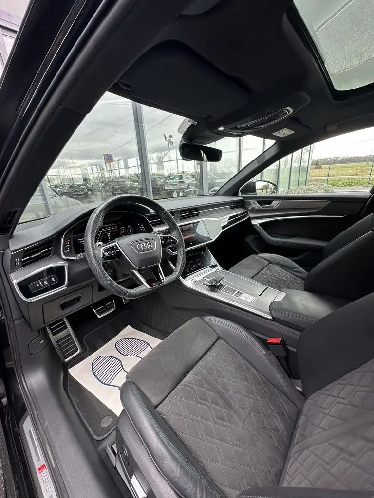 Intérieur noir de l'Audi RS6 Avant 2021 vu côté conducteur, avec volant sport et toit ouvrant panoramique.