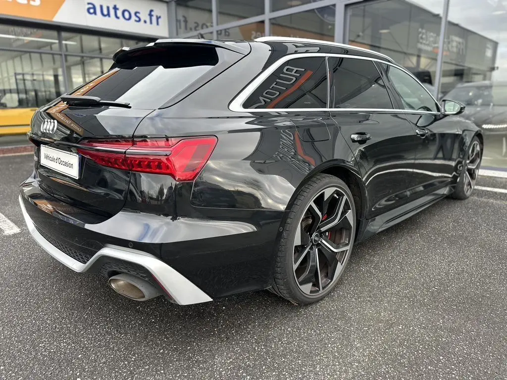 Audi RS6 Avant noire vue en 3/4 arrière droit, avec jantes sport et feux arrière LED distinctifs.