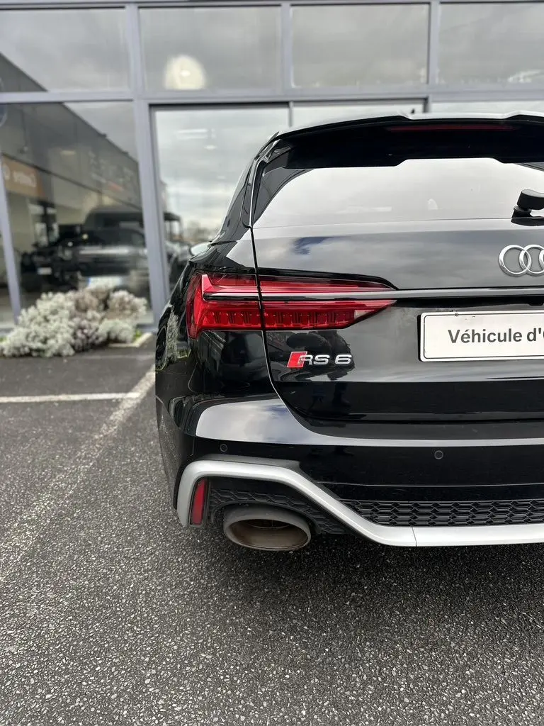 Vue arrière gauche d'une Audi RS6 Avant noire 2021 avec feux LED et double sortie d'échappement distinctive.