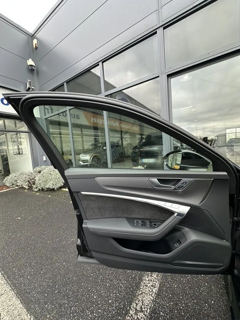 Porte côté conducteur ouverte d'une Audi RS6 Avant noire 2021, montrant l'intérieur avec garnitures noires et inserts argentés.