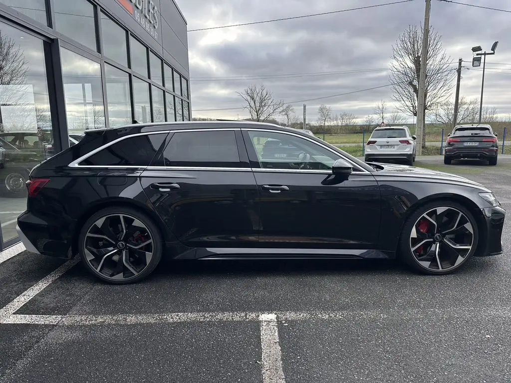 Audi RS6 Avant 2021 noire vue de profil côté gauche, avec jantes sport et étriers de frein rouges visibles.