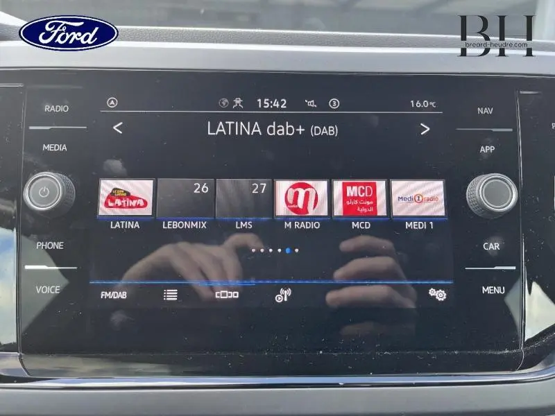 Écran tactile central de la Volkswagen Polo 2022 en Reflet d'Argent, affichant les radios DAB avec commandes autour.