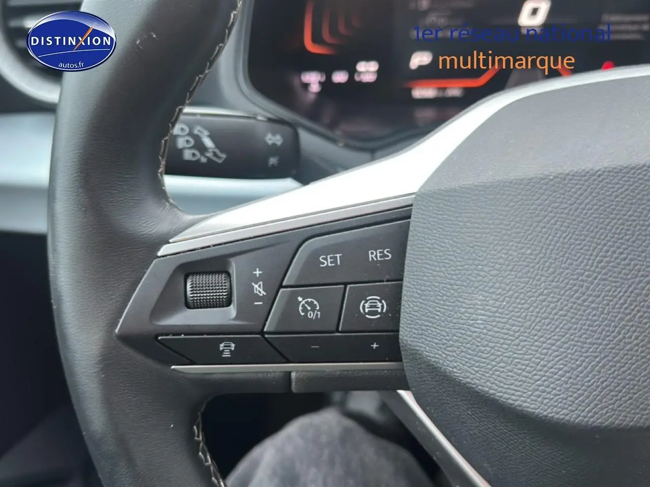 Gros plan sur le volant cuir noir multifonction du SEAT Arona 2025 avec commandes de régulateur de vitesse visibles.