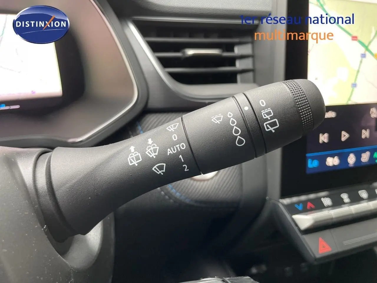 Gros plan sur la commande des essuie-glaces dans l’habitacle du Renault Symbioz 2026, avec écran tactile en arrière-plan.