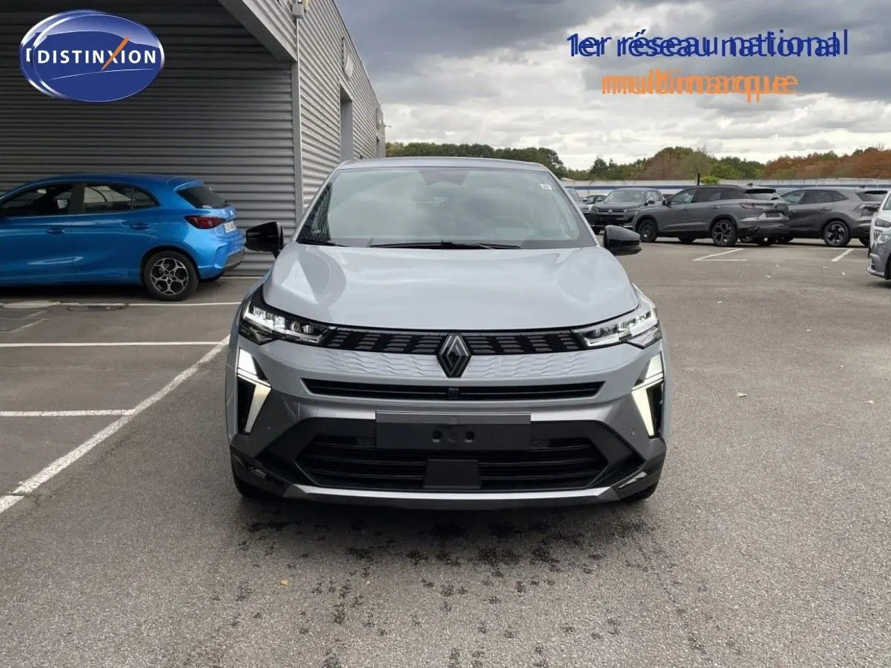Vue frontale d'une Renault Symbioz gris Rafale métal avec éclairage LED et calandre moderne sur fond neutre.