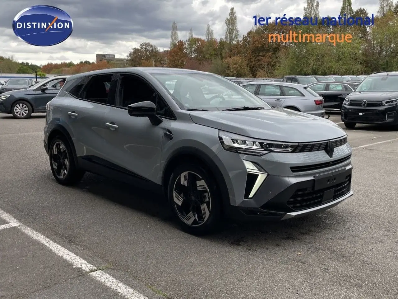 Renault Symbioz gris Rafale métal en 3/4 avant droit, SUV hybride avec feux LED et jantes noires distinctives.