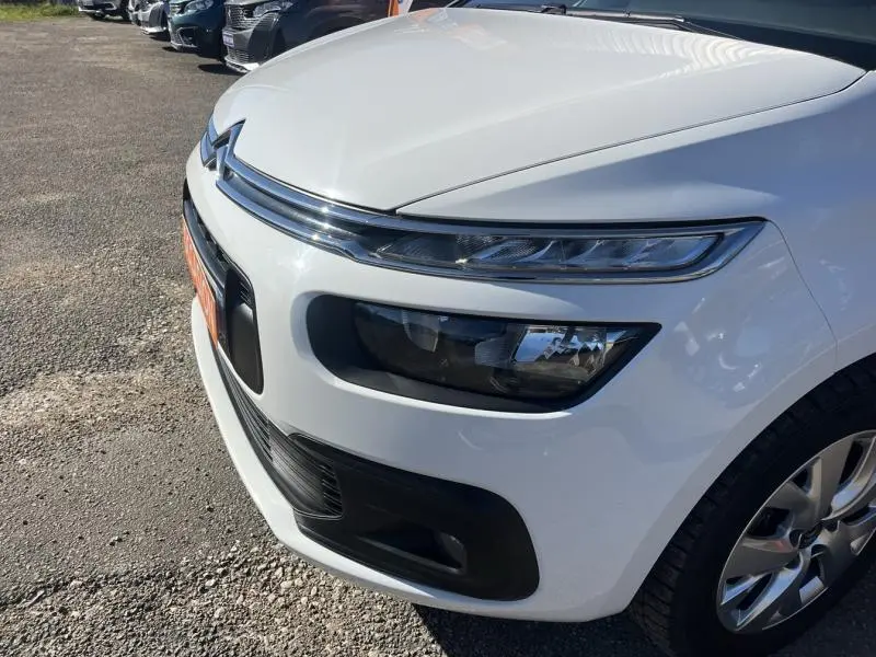 Gros plan sur l'avant droit blanc banquise du Citroën Grand C4 Spacetourer avec phares LED et calandre chromée.