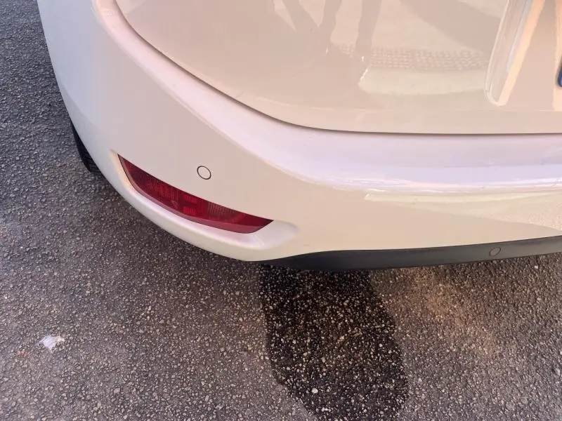 Gros plan sur le coin arrière gauche blanc banquise du Citroën Grand C4 Spacetourer avec feu antibrouillard et capteur de recul.