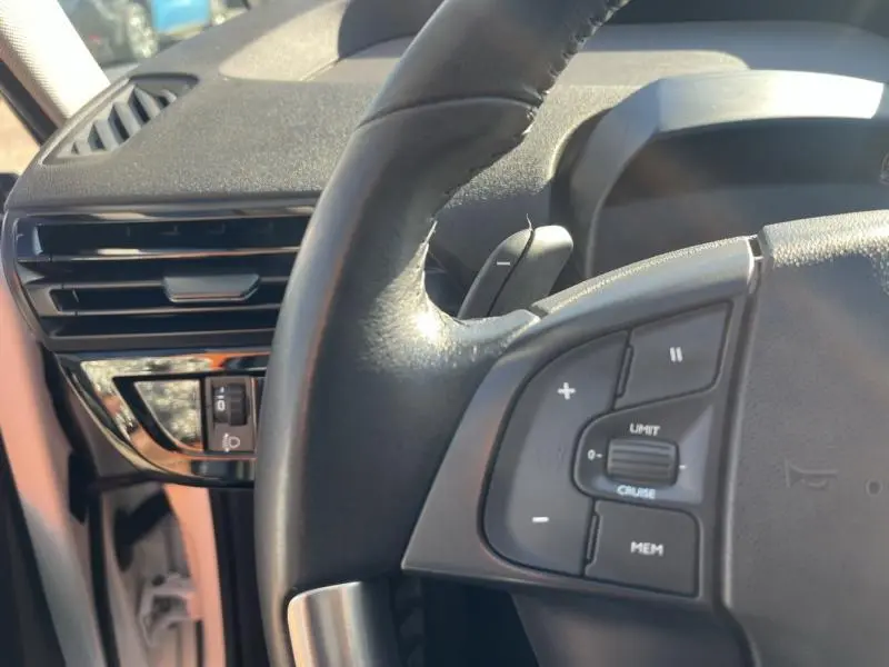 Gros plan sur le volant cuir multifonction et la commande des phares à gauche du tableau de bord du Citroën Grand C4 SpaceTourer blanc.