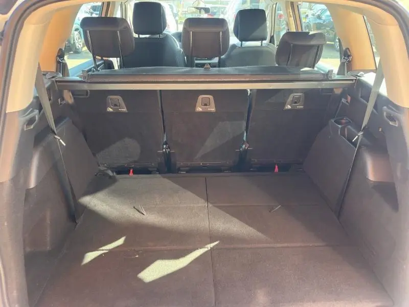 Coffre spacieux du Citroën Grand C4 Spacetourer 2020 avec sièges arrière noirs rabattus et habillage intérieur sombre.