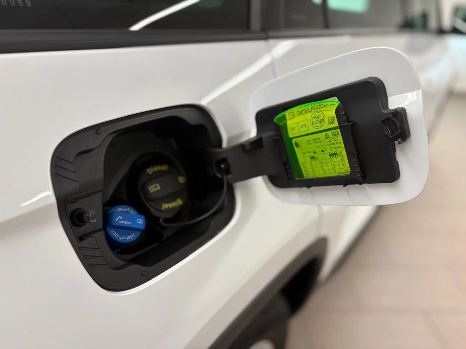 Gros plan sur la trappe à carburant blanche lune d'un Skoda Kodiaq 2022, avec bouchons diesel et AdBlue visibles.