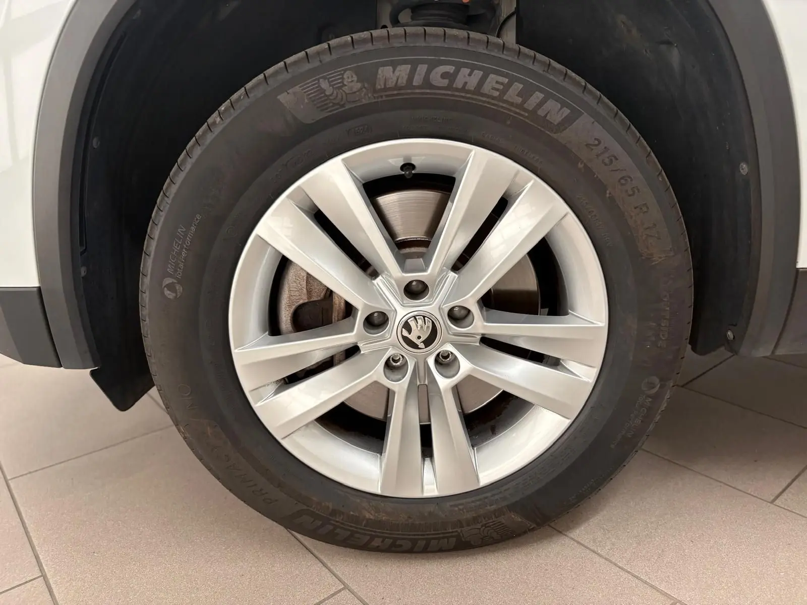 Gros plan sur la roue avant droite du Skoda Kodiaq blanc Lune, avec jante alliage et pneu Michelin visible.