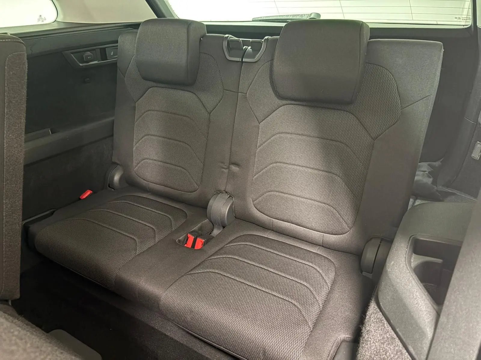 Vue rapprochée de la troisième rangée de sièges noirs du Skoda Kodiaq 2022, avec banquette rabattable et ceintures rouges.