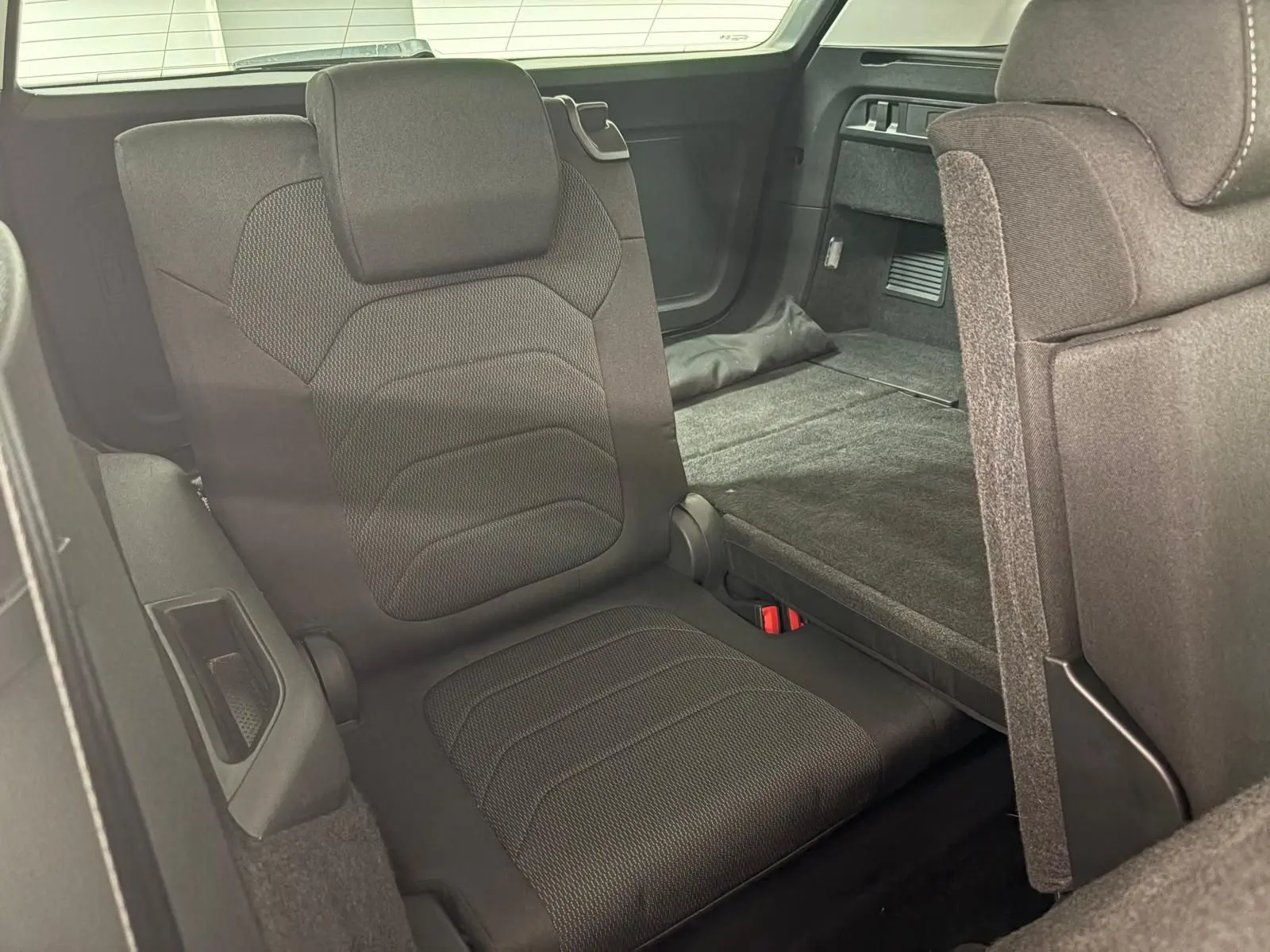 Siège arrière rabattable du Skoda Kodiaq blanc Lune, vue intérieure côté droit avec banquette déployée et coffre visible.