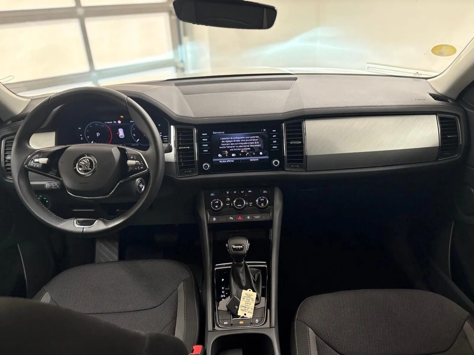 Intérieur du Skoda Kodiaq 2022 vu de face, tableau de bord noir avec écran tactile et volant multifonction.