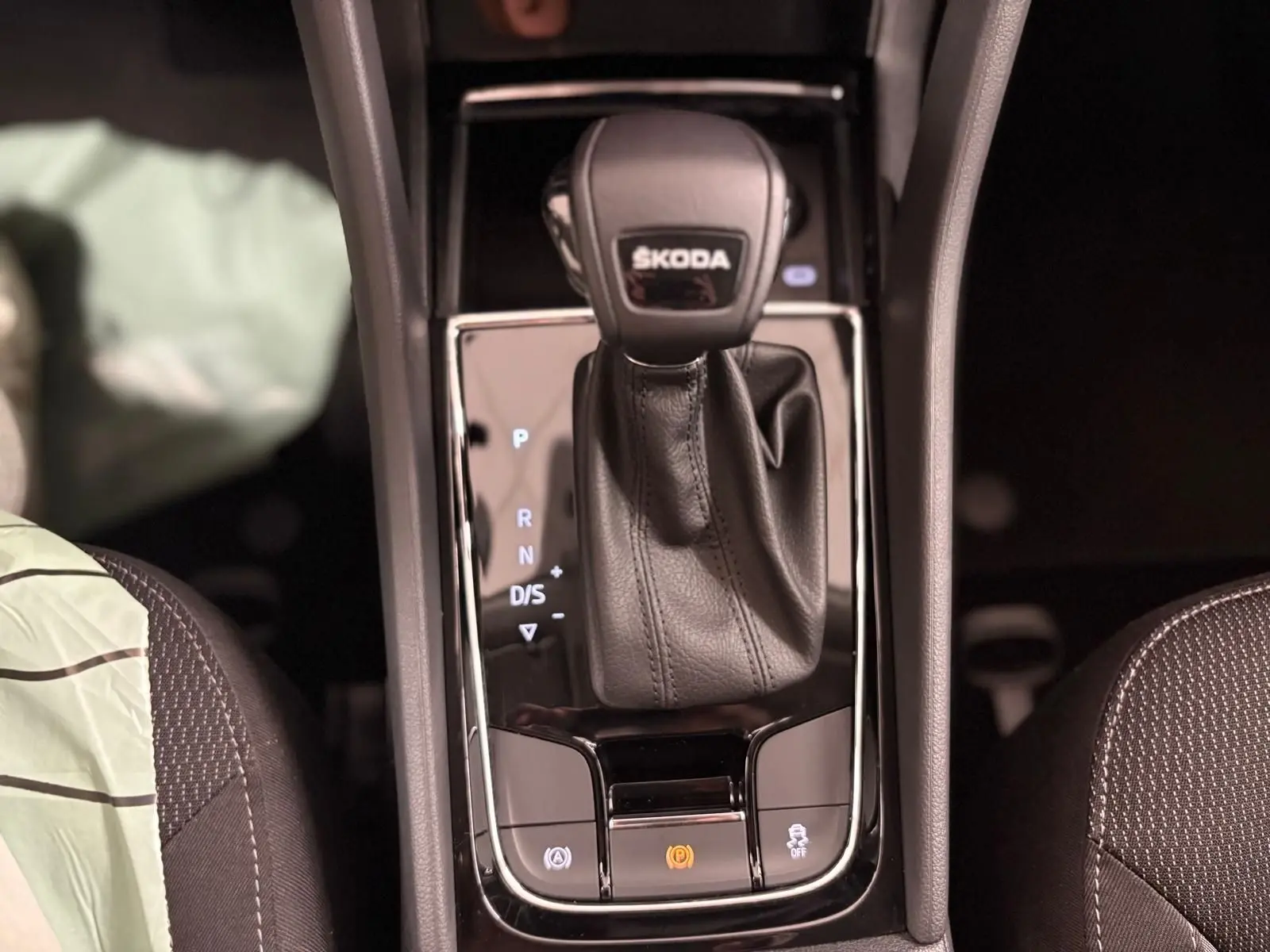 Le levier de vitesses automatique SKODA KODIAQ 2.0 TDI en cuir noir vu de dessus avec commandes éclairées.