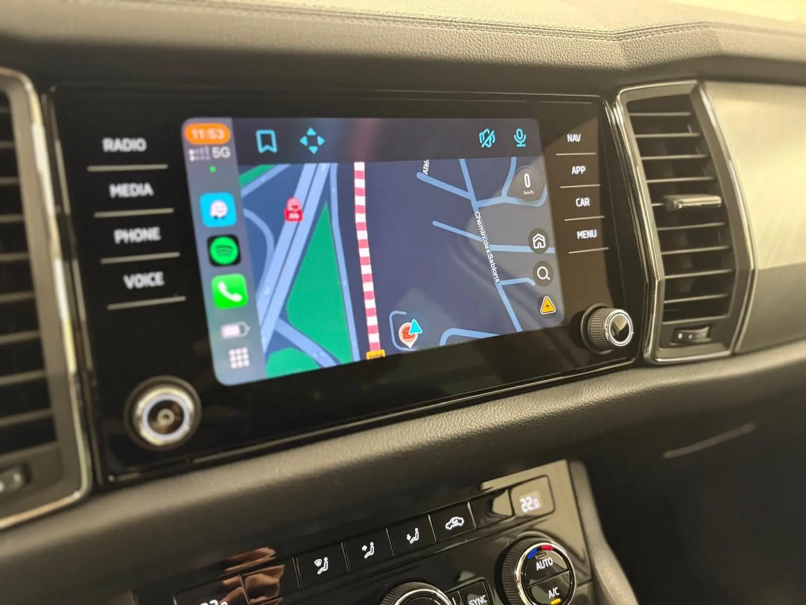 Écran tactile central du Skoda Kodiaq 2022 affichant la navigation, avec commandes multimédia et climatisation visibles.