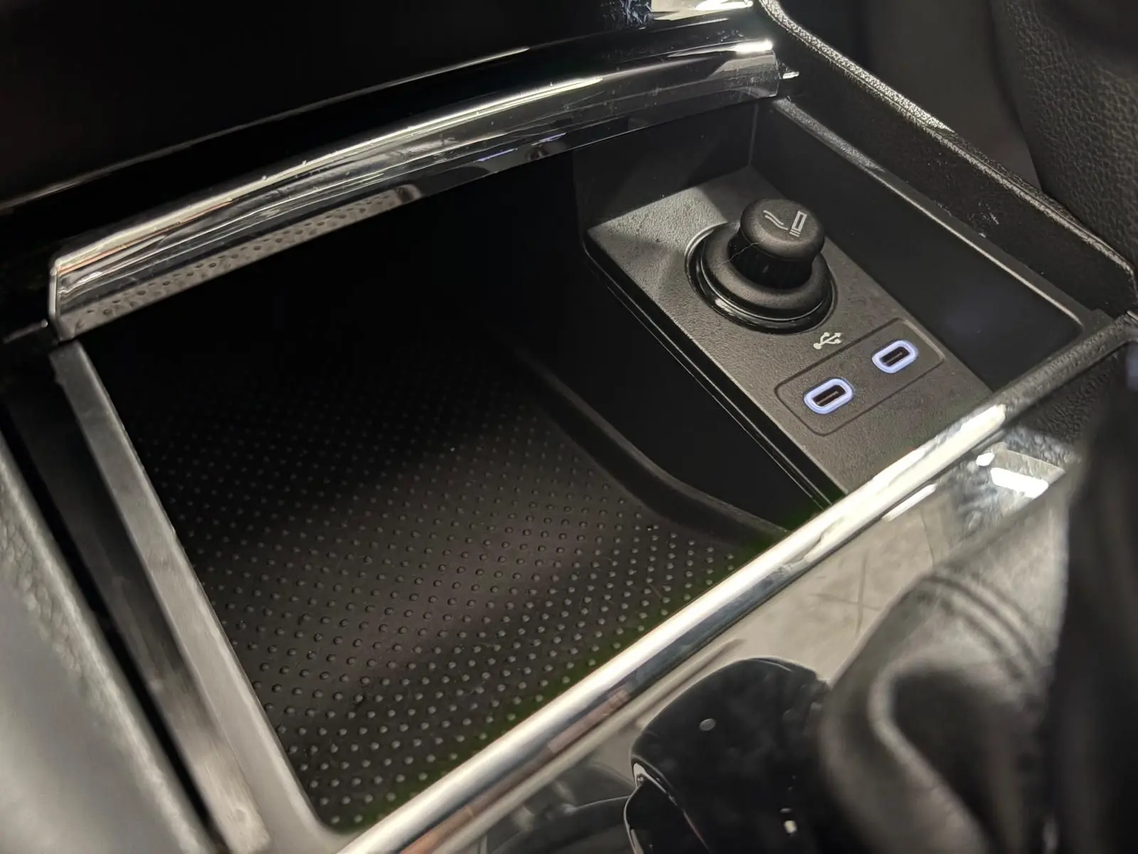 Gros plan sur la console centrale du Skoda Kodiaq blanc, montrant les ports USB et allume-cigare.